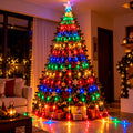Árbol de Navidad con estrella y cascada de luces LED multicolor en una sala